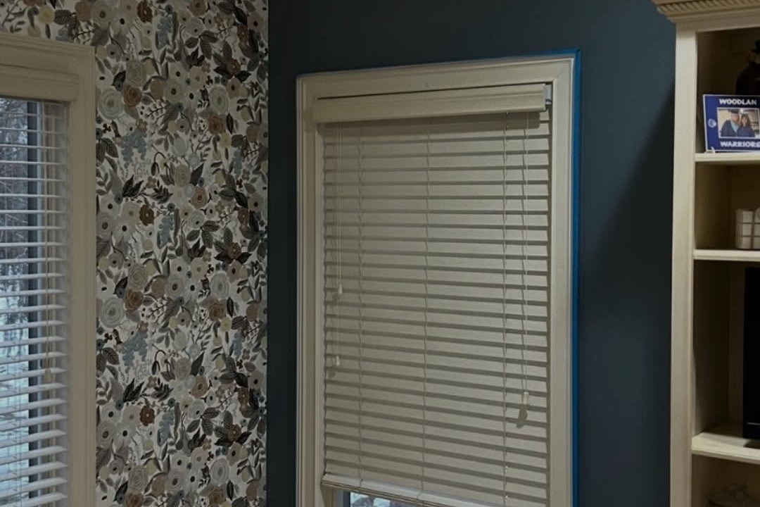 Navy accent wall beside patterned wallpaper and a built-in